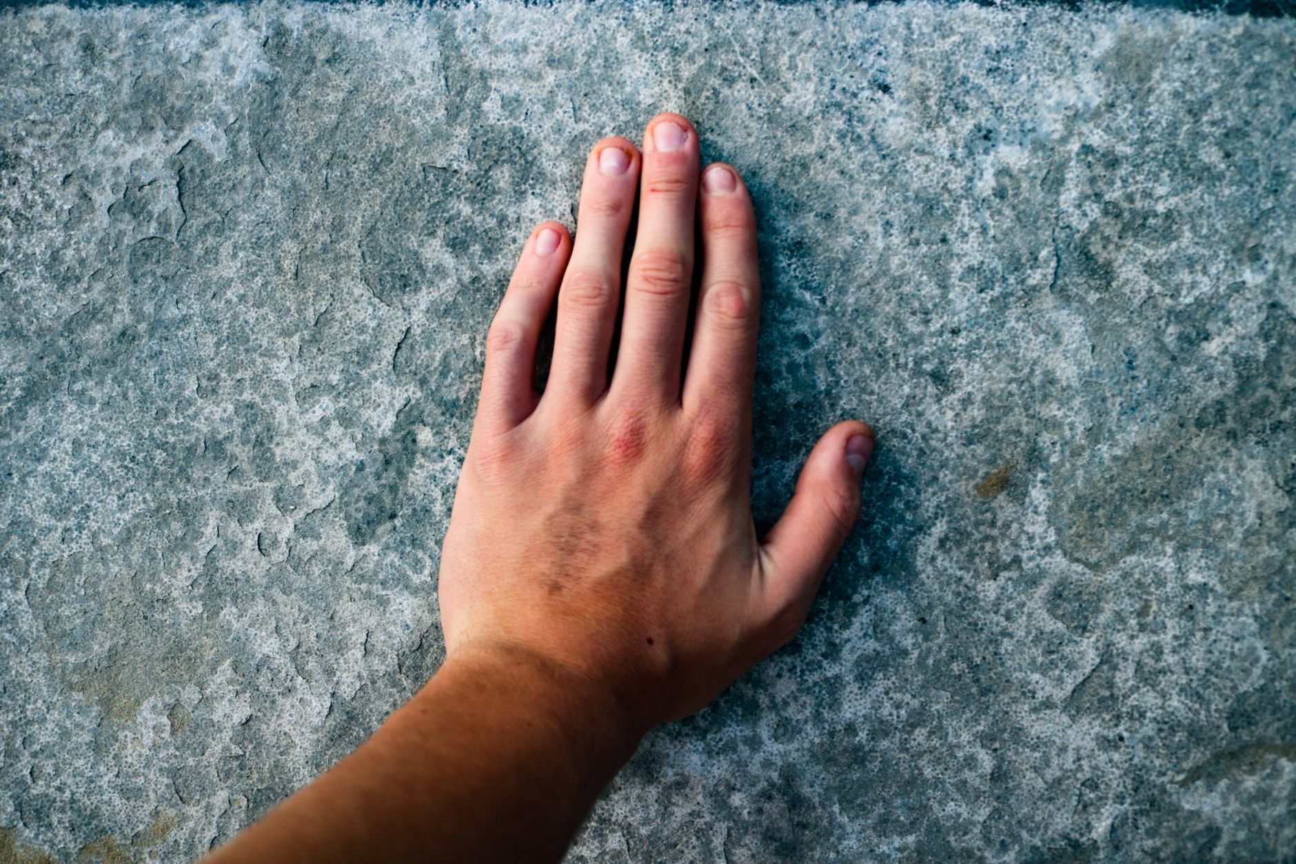 A hand-painted tray held in two hands, brushstroke ridges catching the light at a raking angle